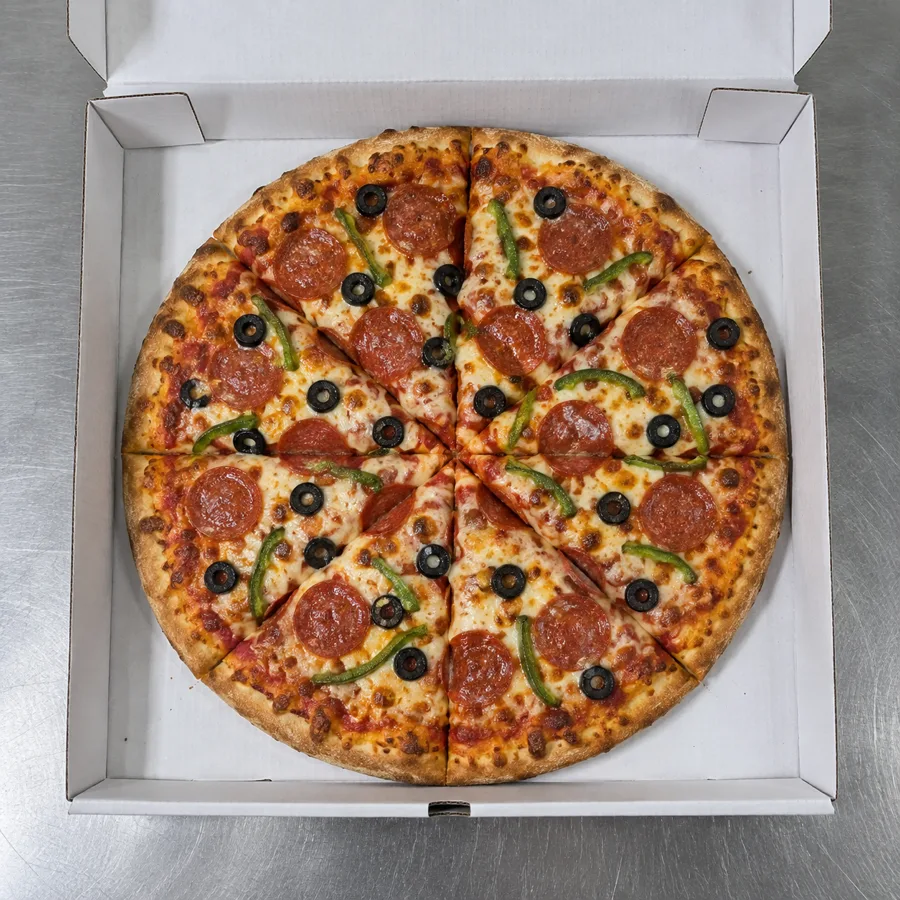 Pizza cut into eight slices in its open box, pepperoni, green peppers and black olives spread evenly. Product check at the prep station.
